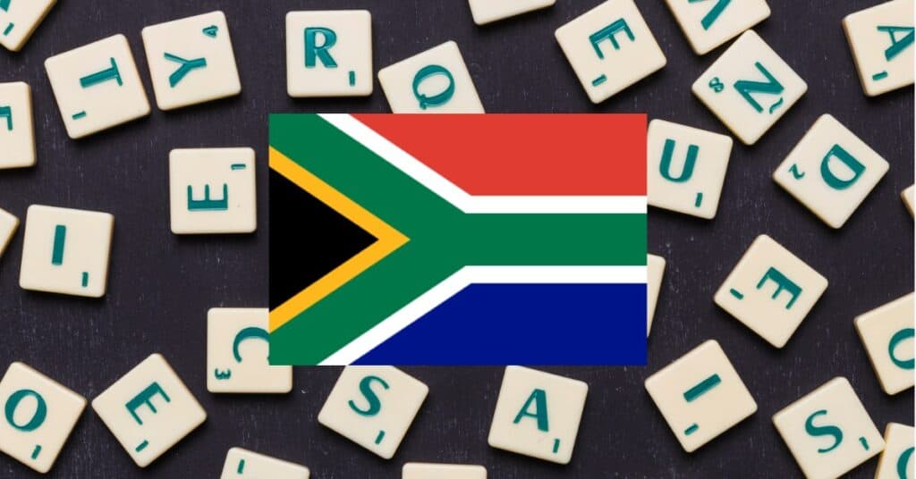 South Africa flag in the center of letter tiles on a captivating black background.