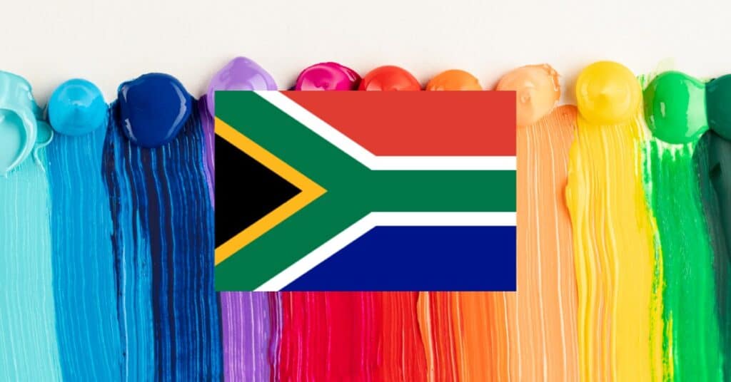 South Africa flag in the center of a captivating rainbow of paint jars, representing a spectrum of colors.