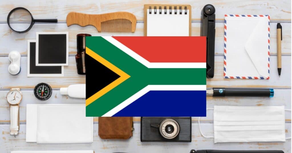 Desktop showcasing items representing nouns: pens, papers, camera, magnifying glass, with South Africa flag in the center.