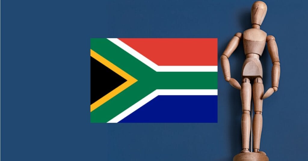 Wooden artist doll representing anatomy with South Africa flag on dark blue background.