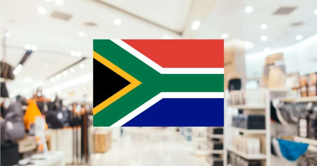 Blurred shopping center background with South Africa flag in the center.