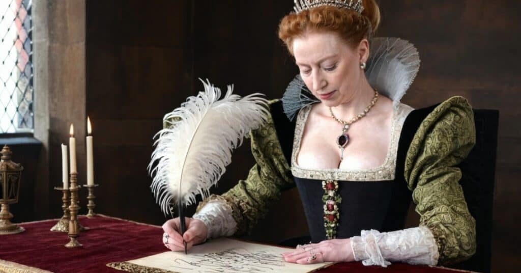 Image of Queen Elizabeth signing the Unity Act with a quill pen