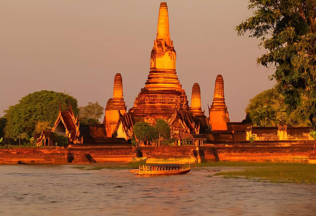 Sunset over Ayutthaya with traditional Thai longtail boat on the Chao Phraya River